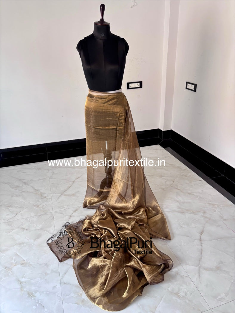 Gold saree on a mannequin against a white wall with 'Bhagalpur Textile' branding.