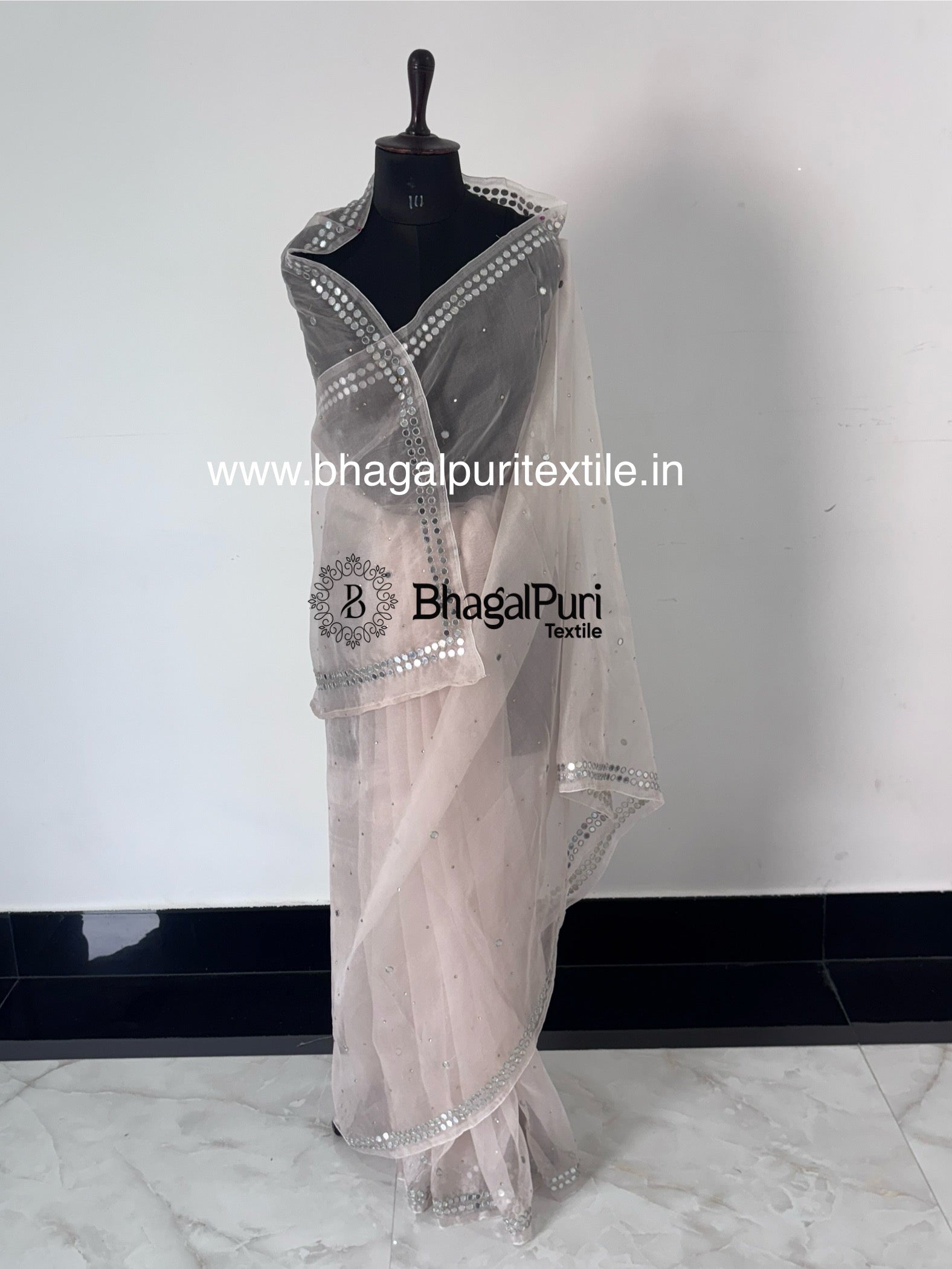 Lightweight designer organza saree featuring handcrafted mirror work, perfect for festivals and celebrations.