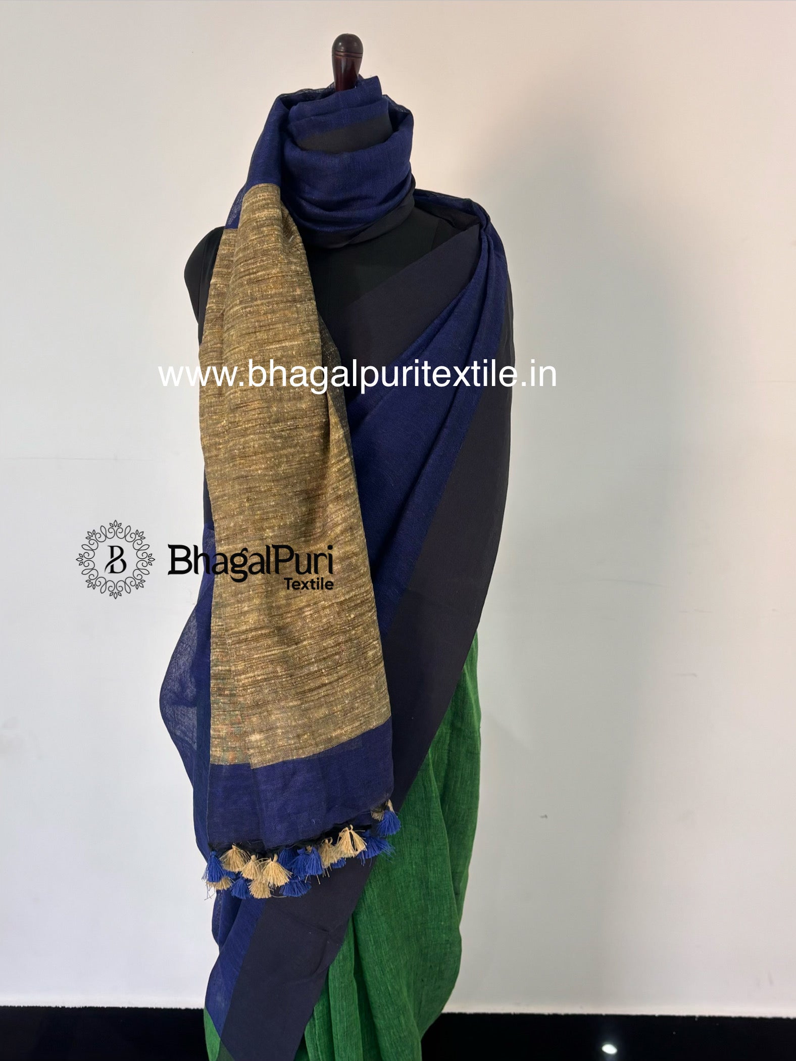 Premium navy blue pure linen saree featuring contrast emerald green giccha pallu and classic handloom texture.