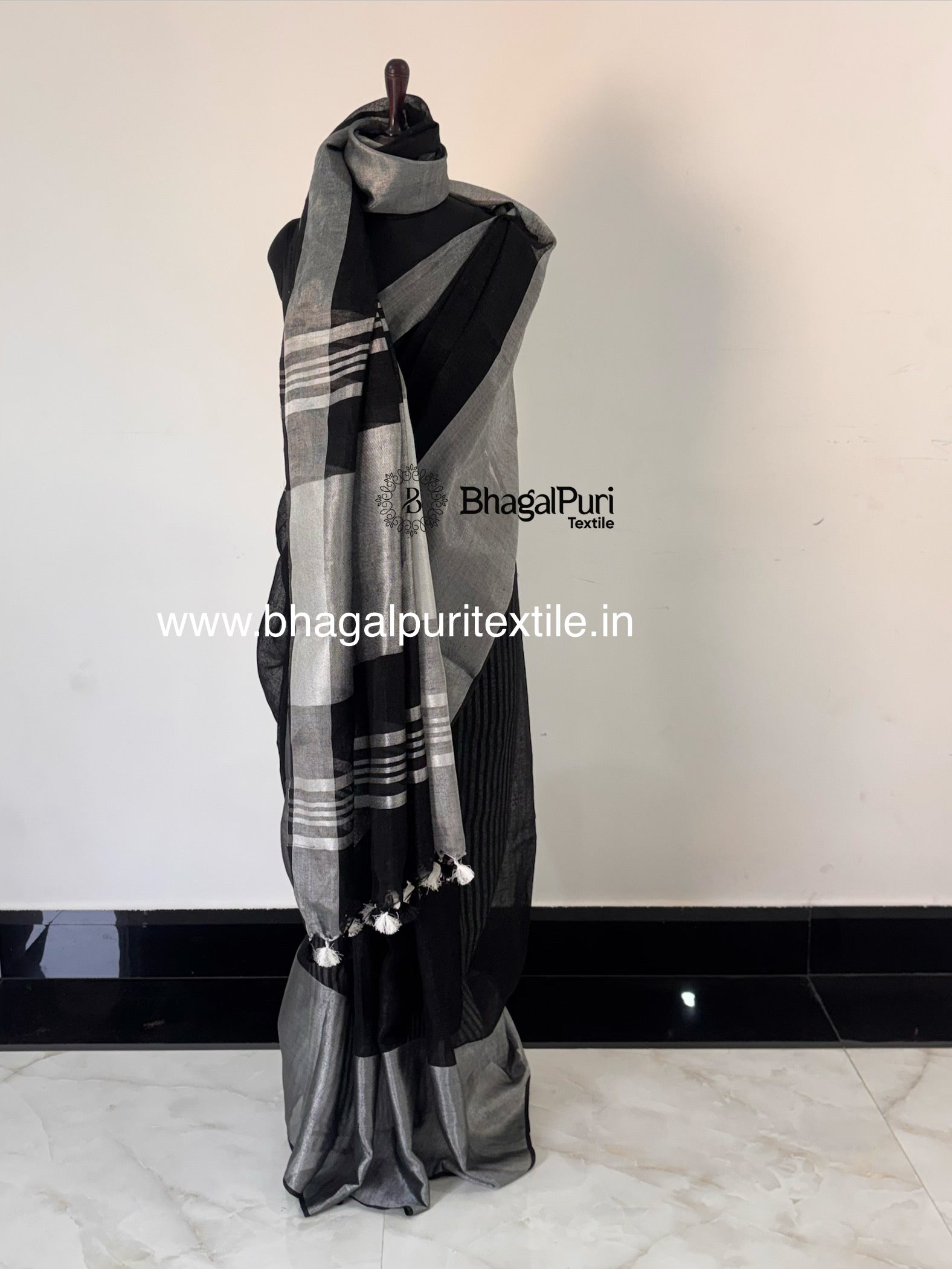 Classic black linen saree with designer silver zari broad border for festive and party wear.