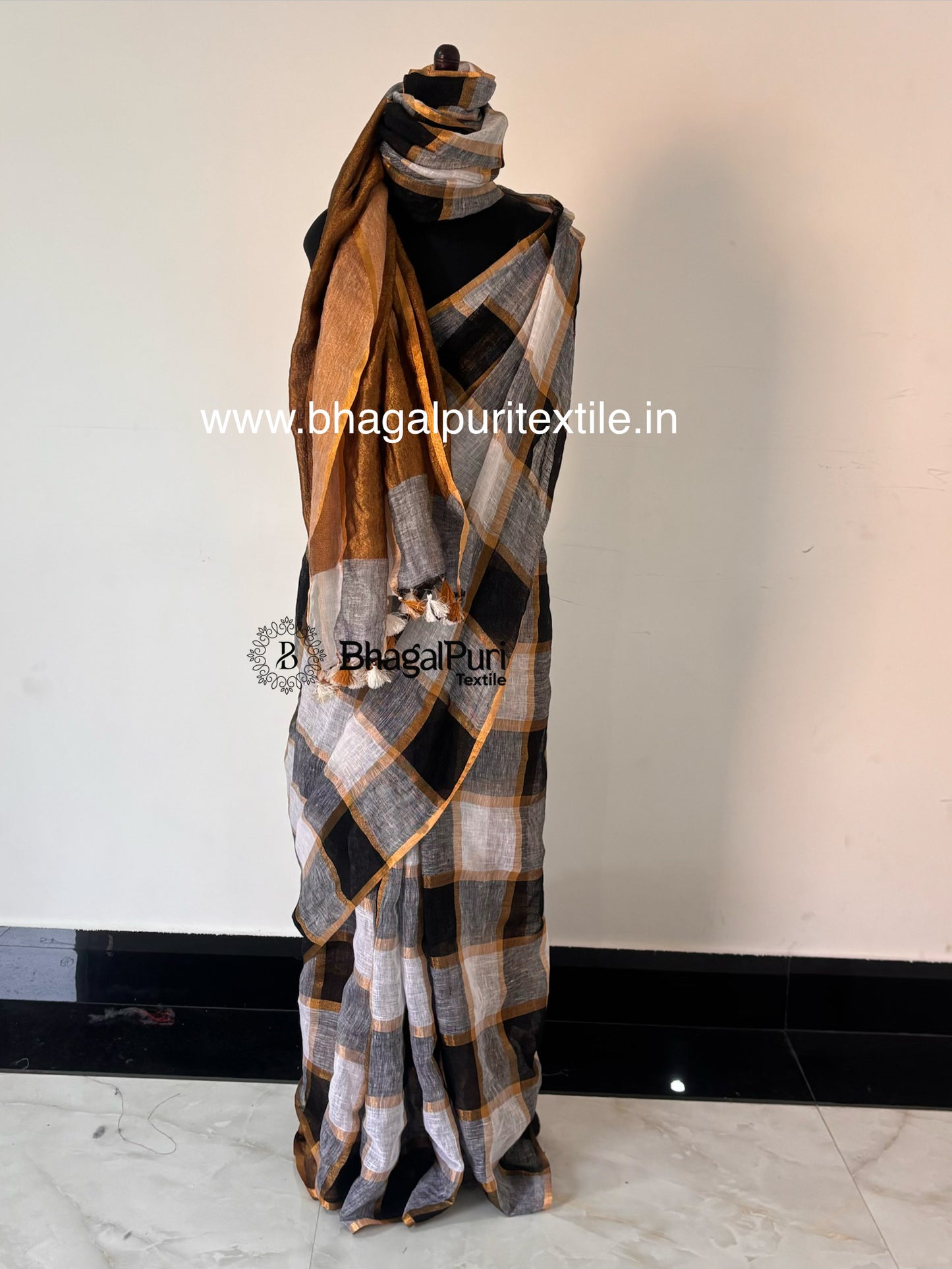 Designer black white linen saree featuring stylish check pattern and traditional zari border