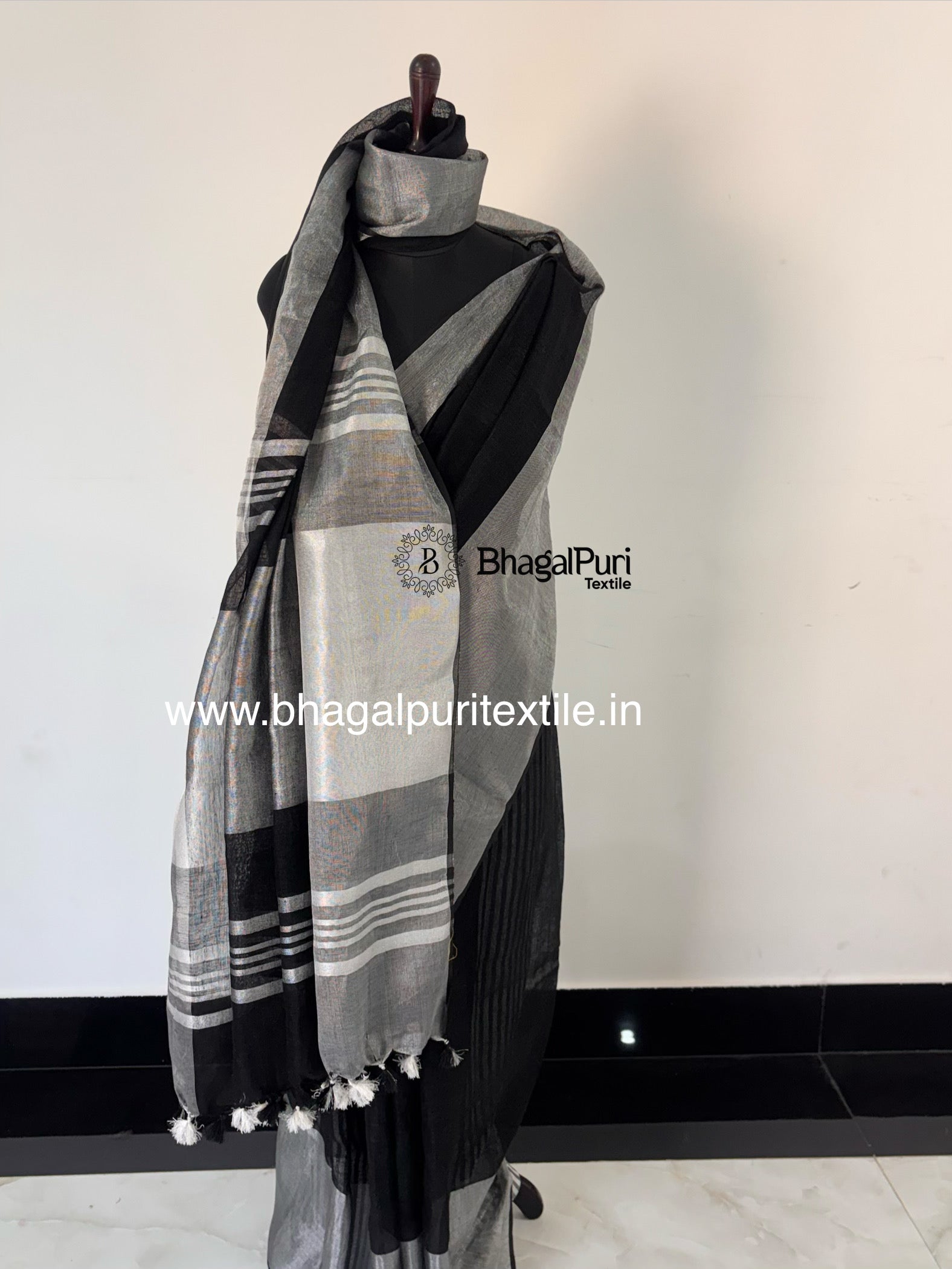 Stylish black linen saree with luxurious silver zari work broad border and lightweight fabric.